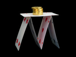 House of cards with gold coins